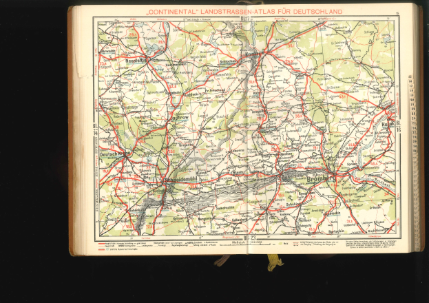 Offenes Buch mit einer detaillierten Karte von Deutschlands Straßen und Autobahnen auf einem schwarzen Hintergrund.