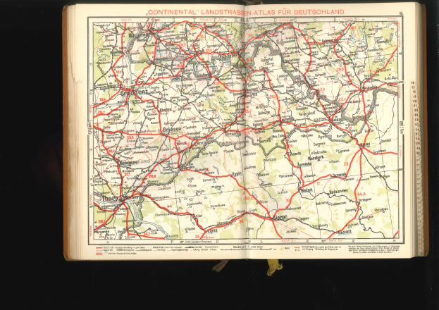 Offenes Buch mit einem detaillierten Kartenbild von Deutschlands Straßen und Autobahnen auf schwarzem Hintergrund.