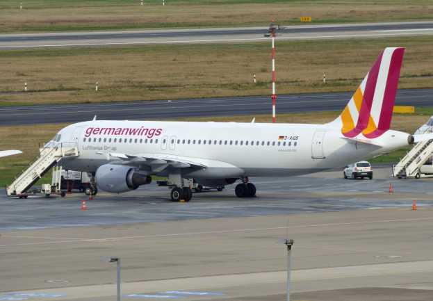 Germanwings Airbus A320-200 am Frankfurt Airport geparkt mit Bodenfahrzeugen, Verkehrskegeln, Pfählen und Gras im Hintergrund.