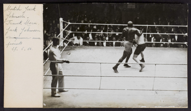 Schwarz-weiß-Foto von zwei Boxern im Ring mit einem Schiedsrichter und Zuschauern, beschriftet mit "Jack Johnson vs Frank Morgan".