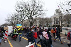 Eine große Gruppe von Menschen marschiert auf einer Straße in Washington, D.C., mit Schildern und Fahrrädern unter einem klaren blauen Himmel am 21. Januar 2020.