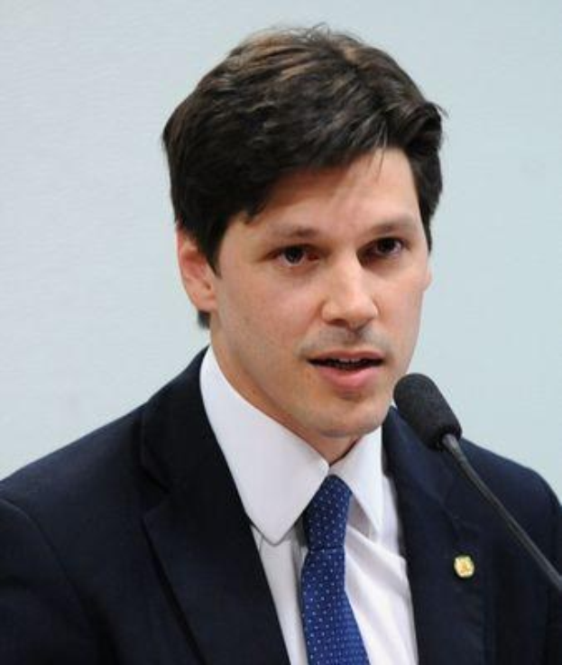 Ein Mann im Anzug und mit Krawatte spricht vor einer Wand in ein Mikrofon, wahrscheinlich während er eine Regierungserlaubnis für ein Gesetz zur Verbots des Internetsatzes verkündet.