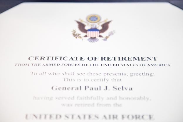 Rahmenurkunde für den Ruhestand von der United States Air Force mit blauem Rand, zentralem Sternschild-Logo innerhalb eines Lorbeerkranzes und einer "Ruhestand"-Bannerschrift, alles in Schwarz gedruckt.