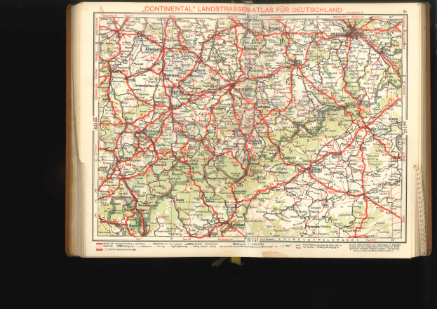 Offenes Buch mit einem detaillierten Kartenausschnitt der deutschen Straßen und Autobahnen vor schwarzem Hintergrund.