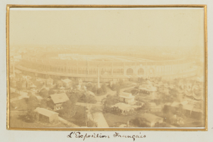 Altes Schwarz-Weiß-Foto eines Stadions, umgeben von Gebäuden, Bäumen und Strommasten, mit Text unten.