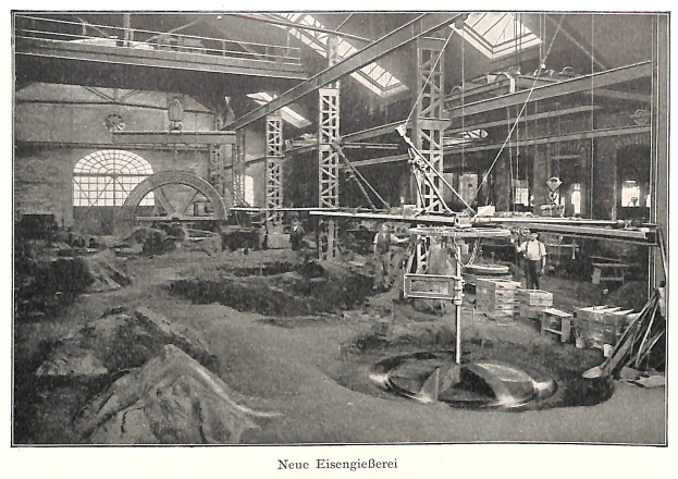 Schwarzes und weißes Foto einer Fabrik mit Arbeitern, die Maschinen bedienen, Metallstangen und -pfosten, beschriftet mit "Neue Eisenglebeerei, die erste Fabrik in Deutschland."