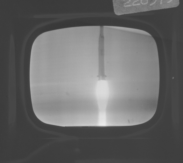 Schwarzes und weißes Foto eines Fernseherbildschirms mit einer Rakete im Fenster und Text oben.