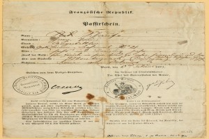 Ein altes, vergilbtes Dokument mit einem kreisrunden, schwarz umrandeten Stempel, das schwarze Tintenbuchstaben enthält, wahrscheinlich ein Brief der deutschen Regierung.