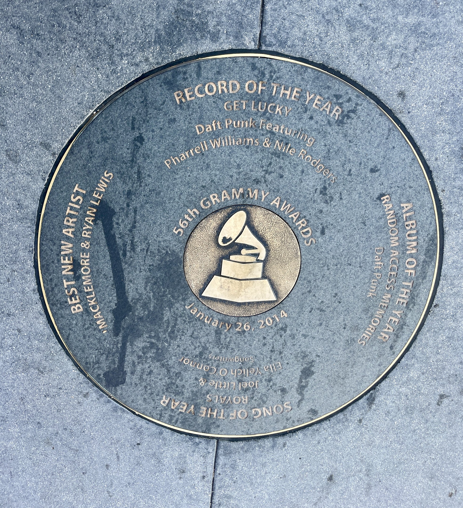 Ein kreisförmiges Hollywood Walk of Fame-Schild, das einen Rekord des Jahres ehrt und einen Text sowie ein Bild enthält, das in den Boden eingelassen ist.