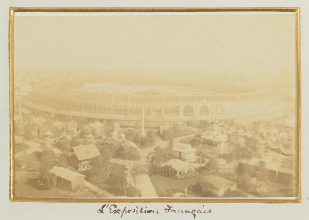 Altes Schwarz-Weiß-Foto eines Stadions in städtischer Umgebung, umgeben von Gebäuden, Bäumen und Strommasten, mit unten sichtbarem Text.