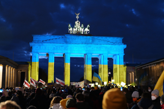 Menschenmenge mit Fahnen und Transparenten vor dem Brandenburger Tor in Berlin