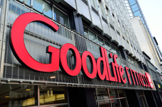 Ein Goodlife Fitness Studio in New York City mit Glaswänden und einem Namensschild, umgeben von anderen Gebäuden unter einem sichtbaren Himmel.