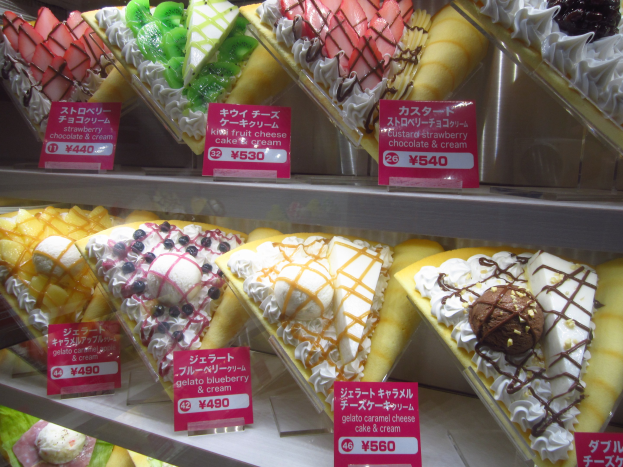 Vitrine voller verschiedener Eissorten mit Preisetiketten in unterschiedlichen Farben, Formen und Geschmacksrichtungen.