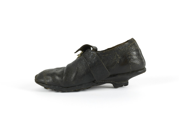 Schwarze Lederschuhe mit klassischem gerundetem Zeh und niedrigem Absatz auf einem weißen Hintergrund, Schnürsenkel zu einer ordentlichen Schleife gebunden, leicht abgenutzter Sohlenbelag.