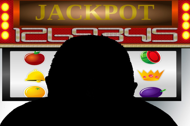 Ein Mann spielt ein Online-Slot-Maschinen-Spiel mit "Jackpot" angezeigt, umgeben von Obst-symbolen.